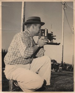 My father, Paul F. Moloney, photographs a Colorado State College (now University of Northern Colorado) football game from the sidelines of Jackson Field in Greeley, Colo., in the fall of 1957. He holds a Speed Graphic press camera. (Photo/Bob Waters)